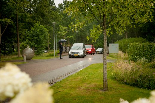 patriciapetrickfotografie- afscheidsmomenten- afscheidsfotograafNoord-holland-DSC_21590120190710 Familie kijkt met lach naar foto buiten beeld in een uitvaart ceremonie, voorop een baar met wade.