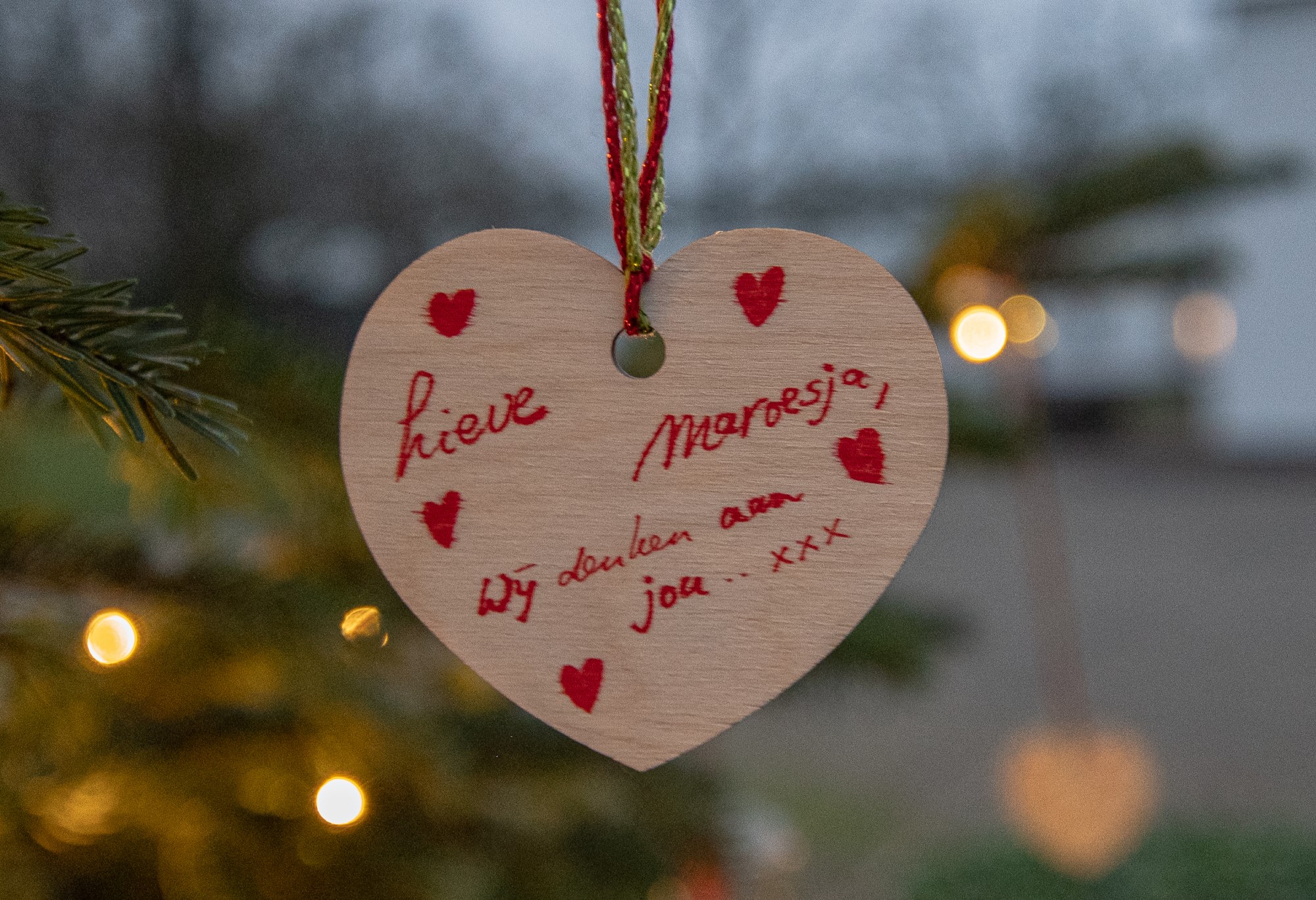 Close up vn een hartje met tekst in de kerstboom