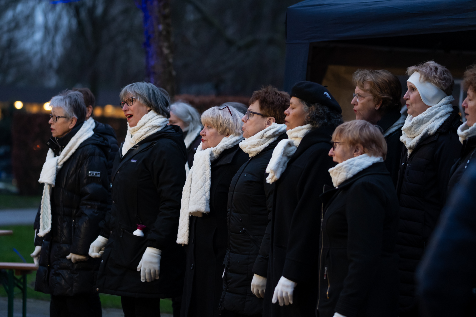 Koor van dames dat buiten zingt in de avond